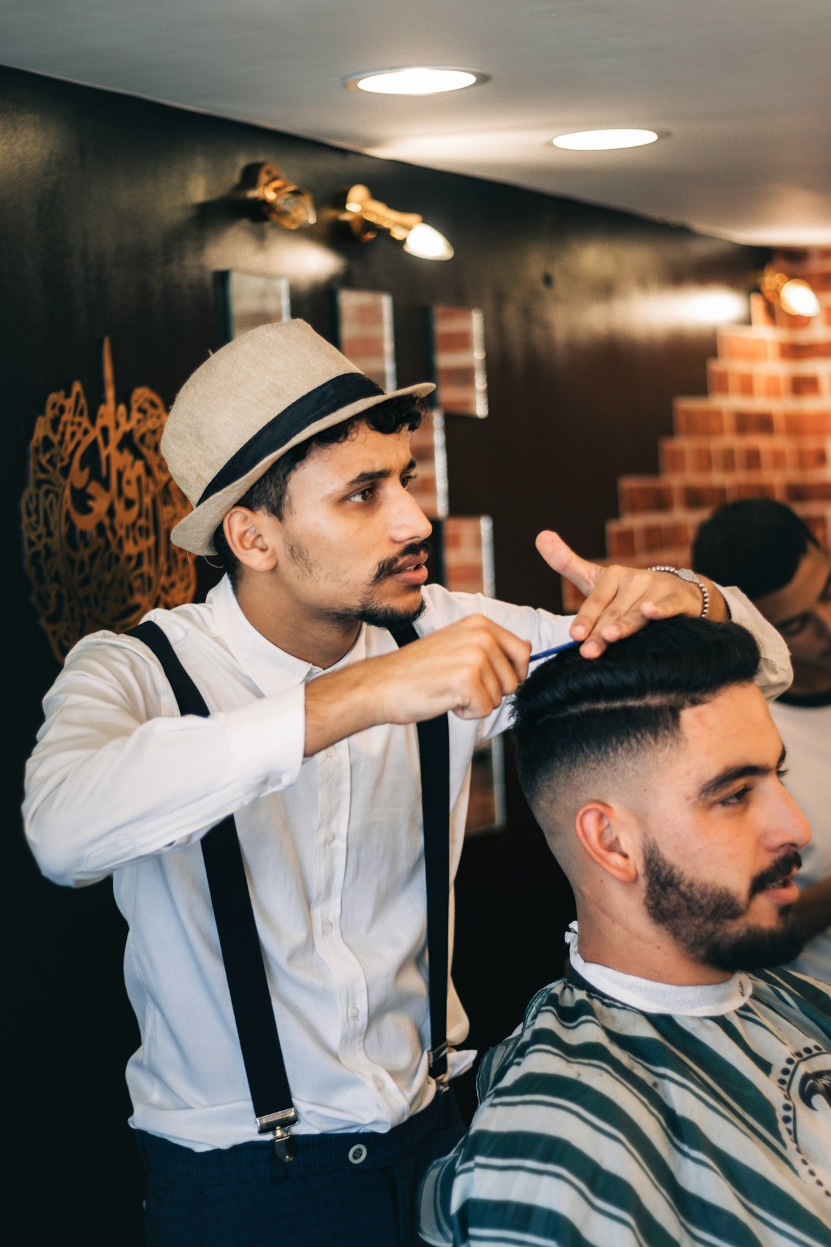 A barber styling a client's hair in a classic shop